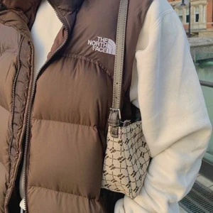 Brun north face puffer väst - Säljer denna eftertraktade bruna north face puffer västen. Den är köpt secondhand/på en vintage butik men är i jättefint skick, den passar de flesta storlekarna💓 köparen står för frakten