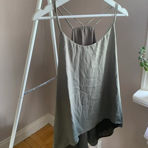 Grönt 2 i 1 linne  - 2 i 1 linne, det går nämligen att vända ut och in för att få en annan färg så en mörkare militärgrön och en mer åt det olivgröna hållet. Köpt utomlands så storlek saknas, skulle uppskatta det till en 36/38a. 