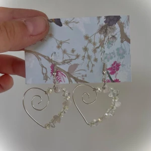 Rosenkvarts och Bergskristall örhängen av sterling silver - 𝚁𝚘𝚜𝚎𝚗𝚔𝚟𝚊𝚛𝚝𝚜 𝚊̈𝚛 𝚎𝚗 𝚔𝚛𝚒𝚜𝚝𝚊𝚕𝚕 𝚏𝚘̈𝚛 𝚔𝚊̈𝚛𝚕𝚎𝚔𝚎𝚗 𝚝𝚒𝚕𝚕 𝚘𝚜𝚜 𝚜𝚓𝚊̈𝚕𝚟𝚊. 𝙳𝚎𝚗 𝚕𝚞𝚐𝚗𝚊𝚛 𝚘𝚜𝚜 𝚘𝚌𝚑 𝚐𝚎𝚛 𝚘𝚜𝚜 𝚝𝚛𝚘̈𝚜t.  𝙱𝚎𝚛𝚐𝚜𝚔𝚛𝚒𝚜𝚝𝚊𝚕𝚕 𝚜𝚢𝚖𝚋𝚘𝚕𝚒𝚜𝚎𝚛𝚊𝚛 𝚔𝚕𝚊𝚛𝚑𝚎𝚝, 𝚟𝚊𝚔𝚎𝚗𝚑𝚎𝚝, 𝚋𝚊𝚕𝚊𝚗𝚜 𝚘𝚌𝚑 𝚜𝚊𝚖𝚔𝚕𝚊𝚗𝚐. 𝙳𝚎𝚗 𝚑𝚓𝚊̈𝚕𝚙𝚎𝚛 𝚍𝚒𝚐 𝚊𝚝𝚝 𝚜𝚊𝚖𝚖𝚊𝚗𝚕𝚊̈𝚗𝚔𝚊 𝚍𝚒𝚗 𝚎𝚗𝚎𝚛𝚐𝚒 𝚖𝚎𝚍 𝚞𝚗𝚒𝚟𝚎𝚛𝚜𝚞𝚖𝚜. 𝙳𝚎𝚝 𝚊̈𝚛 𝚎𝚗 𝚑𝚎𝚊𝚕𝚒𝚗𝚐 𝚔𝚛𝚒𝚜𝚝𝚊𝚕𝚕. 