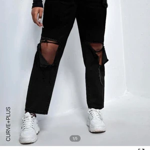 Svarta slitna jeans  - Jeans från shein i strl 2xl. Säljer för de var alldeles för stora för mig. MÅTT:  •längd: 105.5 cm  •Midjestorlek: 99cm  Höftstorlek: 134 cm  Helt oanvända och endast testade. 