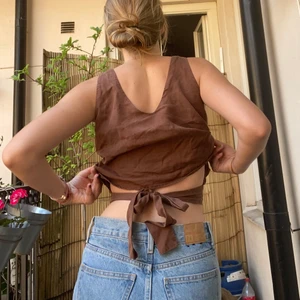 Linne med rosett - Brunt linne som man knyter i ryggen. Passar vid många tillfällen😊 Passar allt ifrån XS till M