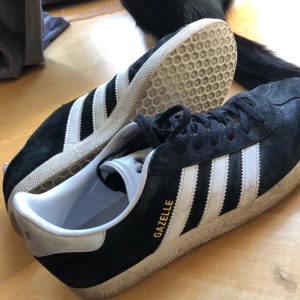 Adidas Gazelle  - Använda men inget fel på insidan  Funkar som slit å släng eller skate skor Det svarta går nog att få helt rent men sulan är svårare