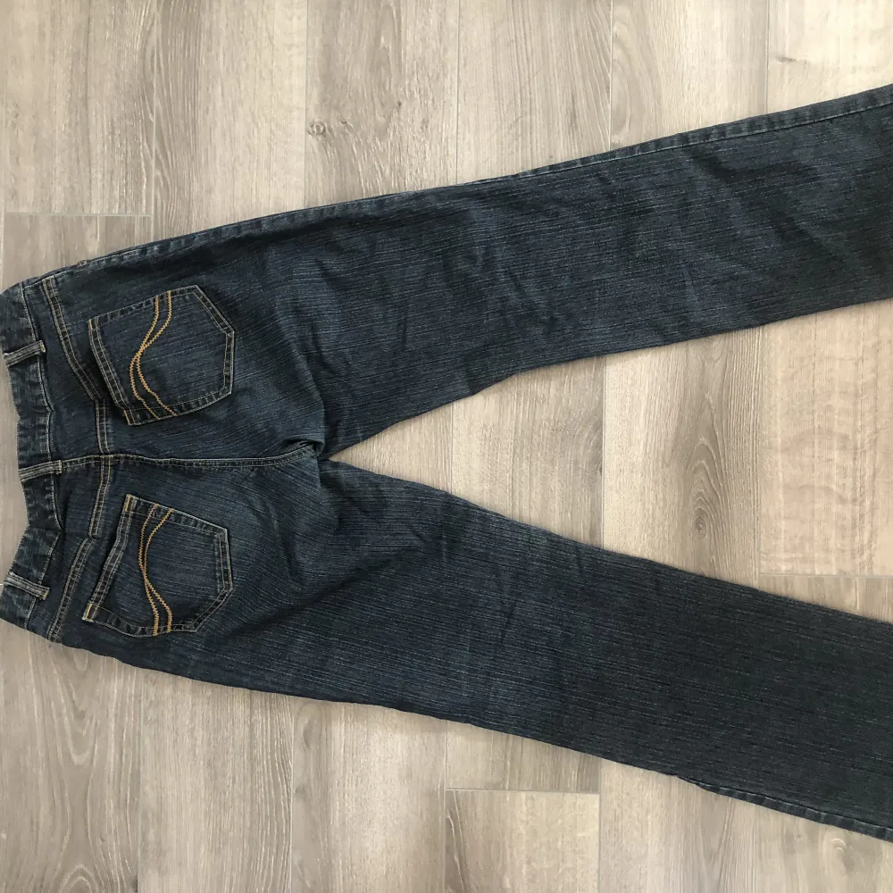 Mörkblå midrise bootcut jeans som är insydda i midjan. Jeans & Byxor.