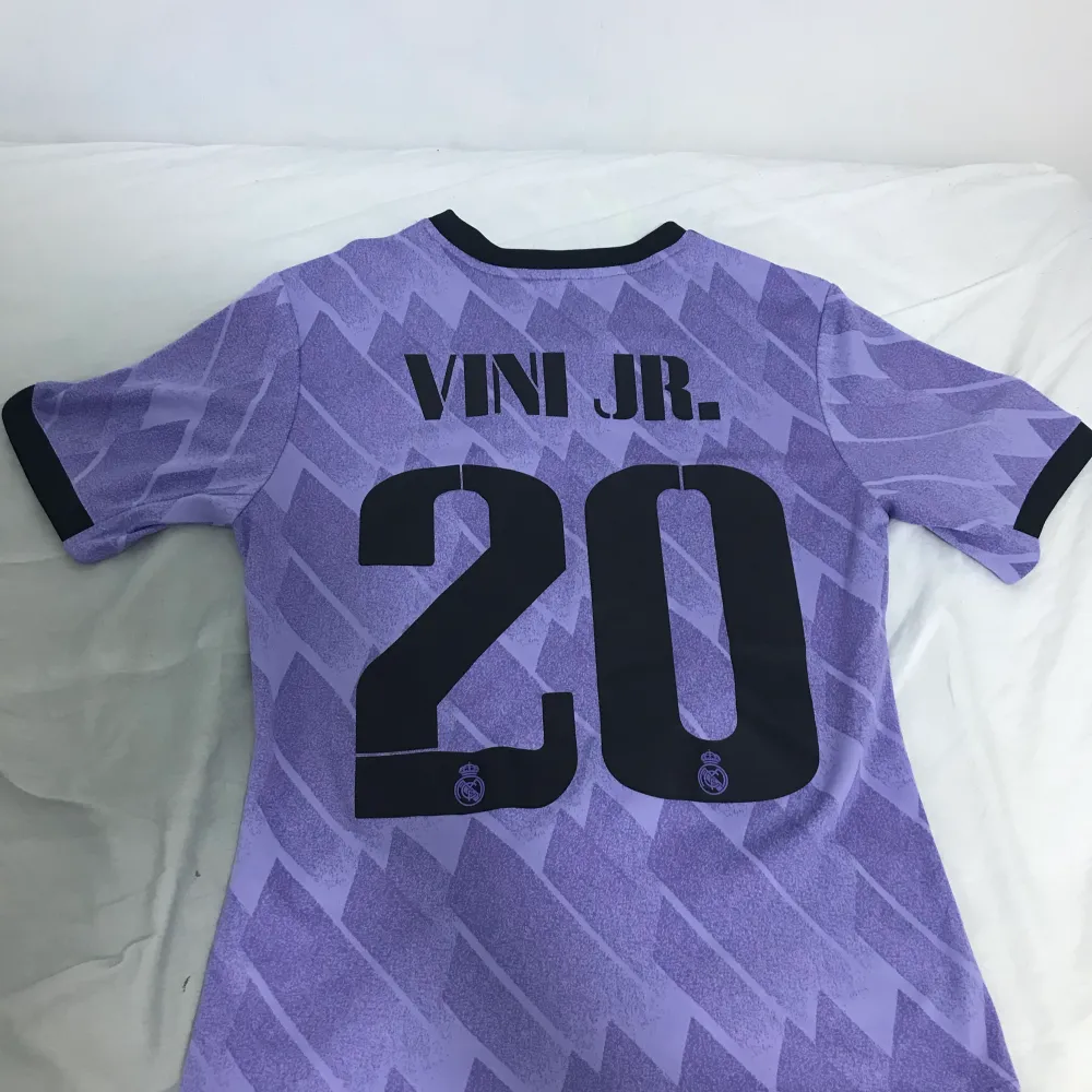 Real Madrid bortaställ 22/23 player version. Vini Jr på ryggen storlek S, använd få gånger. Det ända som är ett minus är den lilla fläcken vid klubbmärket, men som syns knappt inte. Säljer denna tröja för 300kr.. T-shirts.