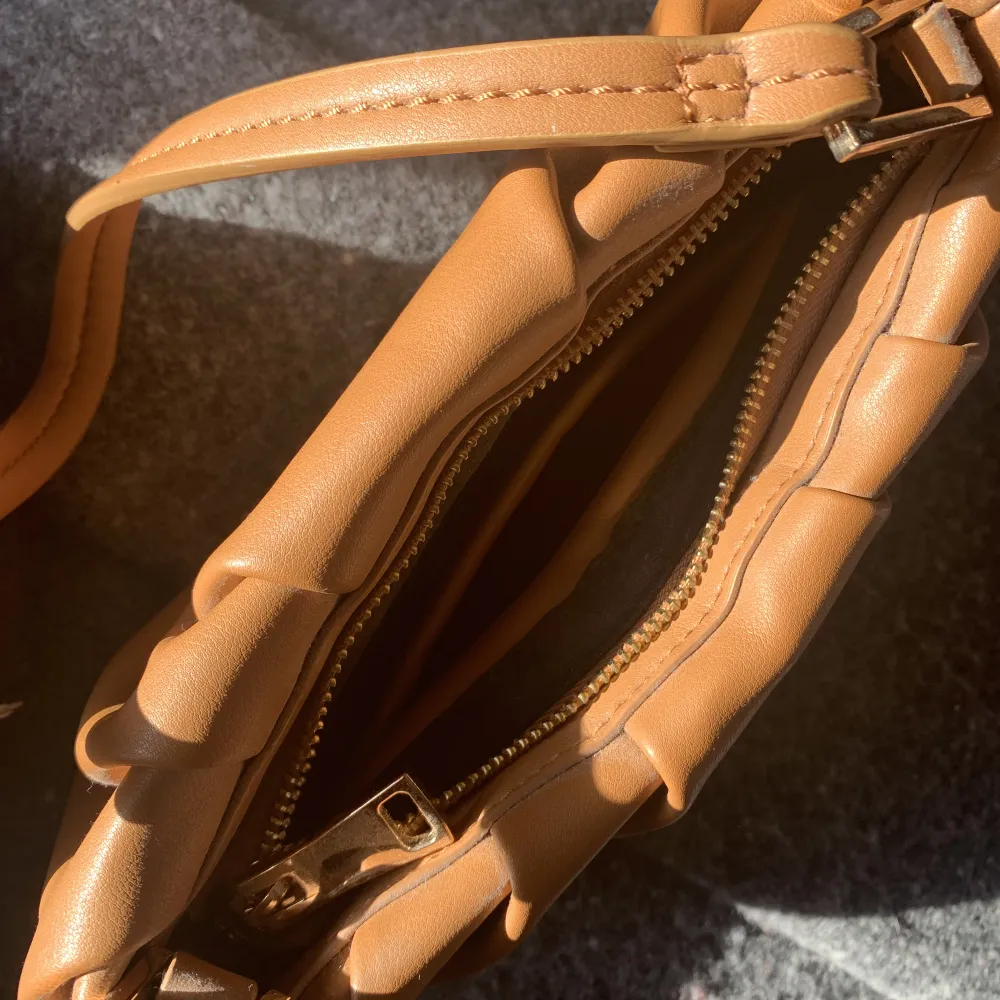 En fin brun handväska med guld detaljer. Ett litet fack innuti och ett stort💞💞. Väskor.