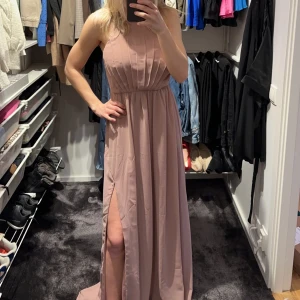 Rosa balklänning - Puderrosa vad jag skulle säga, balklänning. Räcker ner till marken och lite till för mig som är 177cm. Jättefina och gulliga detaljer i ryggen 🫶🏼. Aldrig använd (prislappen kvar)