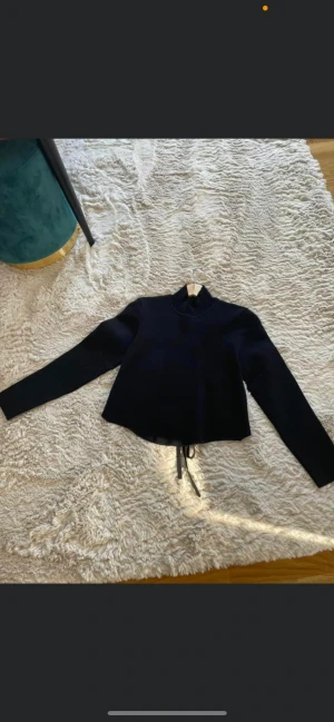 Fest topp - En superfin svart tröja med öppen rygg i strl L (passar en s och m också). Skick: inga anmärkningar!  Material: 55% viskos och 45% nylon.   