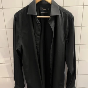 Svart skjorta - En svart skjorta från Dressmans premium kollektion i storlek L (41/42). Perfekt till kostym!