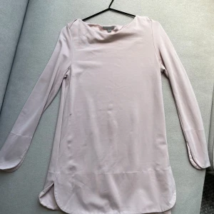 Rosa topp COS - 💗Vad: Topp frå COS i längre modell med fina detaljer vid ärmar och plaggslut.  💗Färg: Puderrosa 💗Storlek: S 💗Skick: Använd i fint skick. En liten noppra mitt på plagget och slitningar av tvätt längs ena ärmen. Inget som syns. 