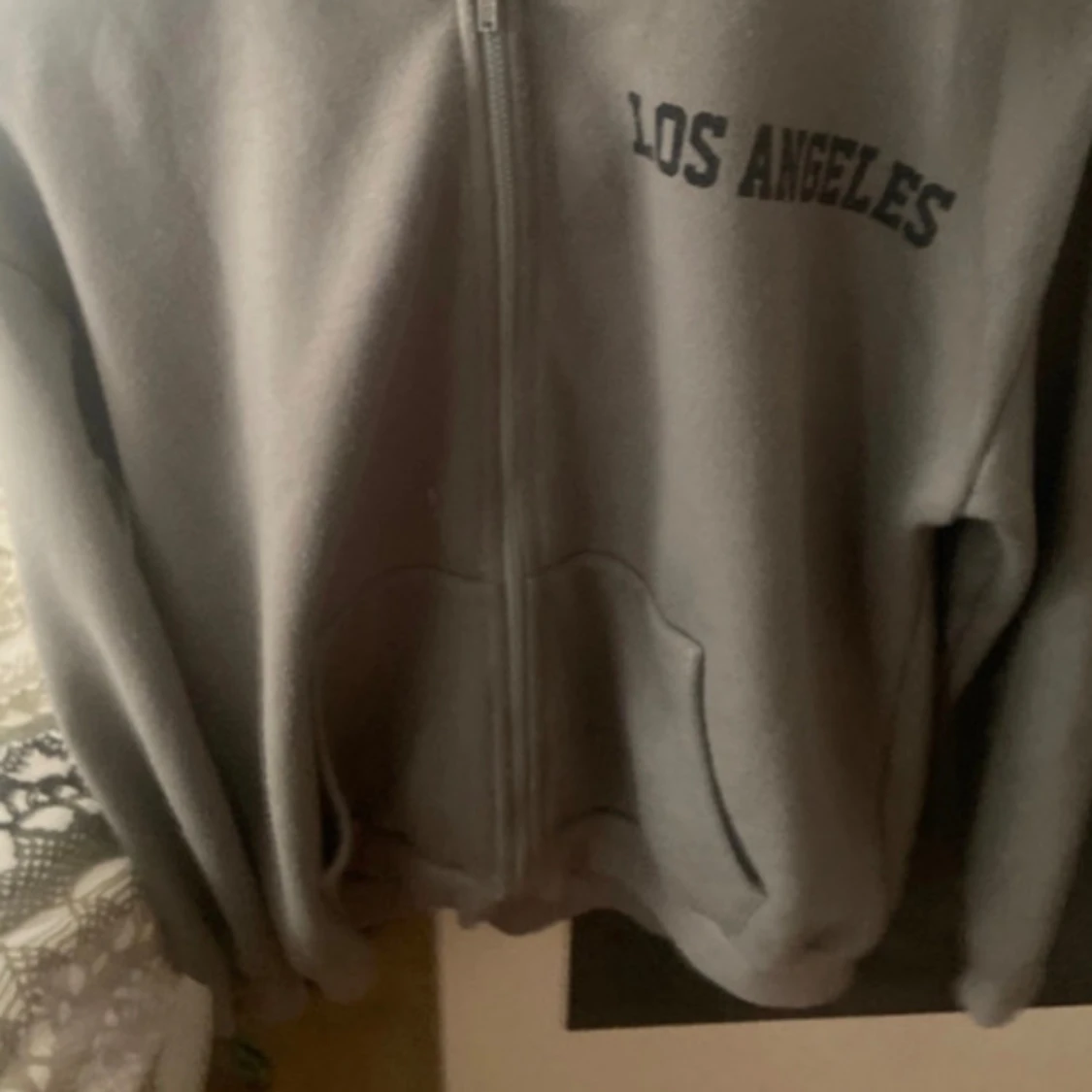 Grå y2k grunge hoodie med svart stjärna på ryggen och liten text 