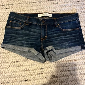  Jeans shorts  - Säljer mina jeans shorts från Abercrombie and Fitch, jätte fina mörkblåa jeans shorts och väldigt lågmidjade. Säljer pga att jag har flera shorts och behöver inte så många. Midjemåttet är 40 cm rakt över. Shortsen är i bra skick och aldirg använda.