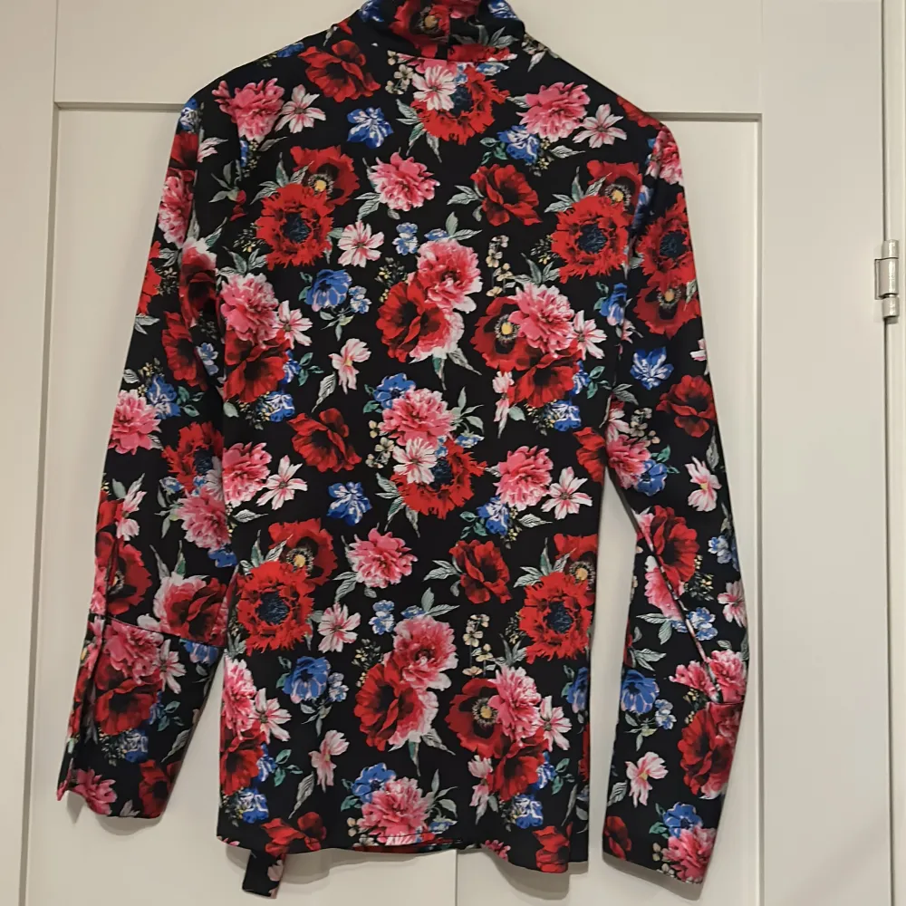 Wrap-around blus med blommönster. Använd fåtal gånger. Blusar.