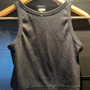 Topp - Svart glittrig tank topp från hm. Inte särskilt använd men har blivit lite nopprig.