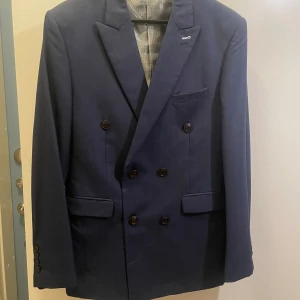 Full kostym  - Kostymbyxor- storlek 33, Kavaj - storlek 52 (allt sitter som S). Marinblå, från Suitcube (fodral ingår)