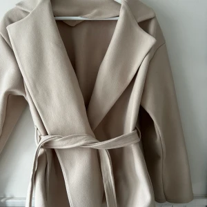 Beige kappa - Säljer min beige kappa som tyvärr inte kommer till användning. Använd Max 2 gånger och inga slitningar eller lösa trådar.