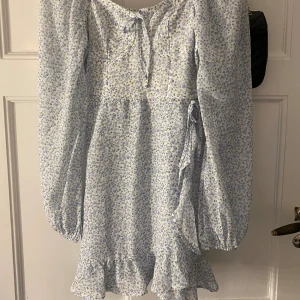 Blåblommig klänning - Säljer denna jätte fina klänning nu till sommaren. Vit med ljusblå blommor på och otroligt skönt material. Köpt förra året men kommer ej till användning 💘
