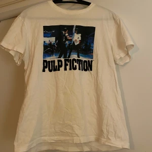 Pulp Fiction t-shirt - T-shirt med Pulp Fiction tryck från Bershka. Liten fläck men inte synlig på håll. I övrigt är tröjan i fint skick :) 