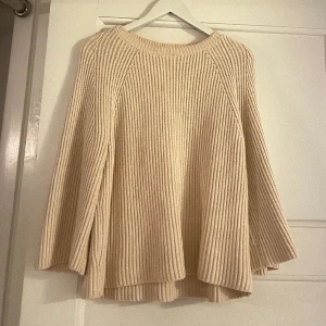 Stickad tröja   - Superfin kabelstickad tröja i ljusrosa/beige med vida ärmar. Nästintill oanvänd så väldigt fint skick! 