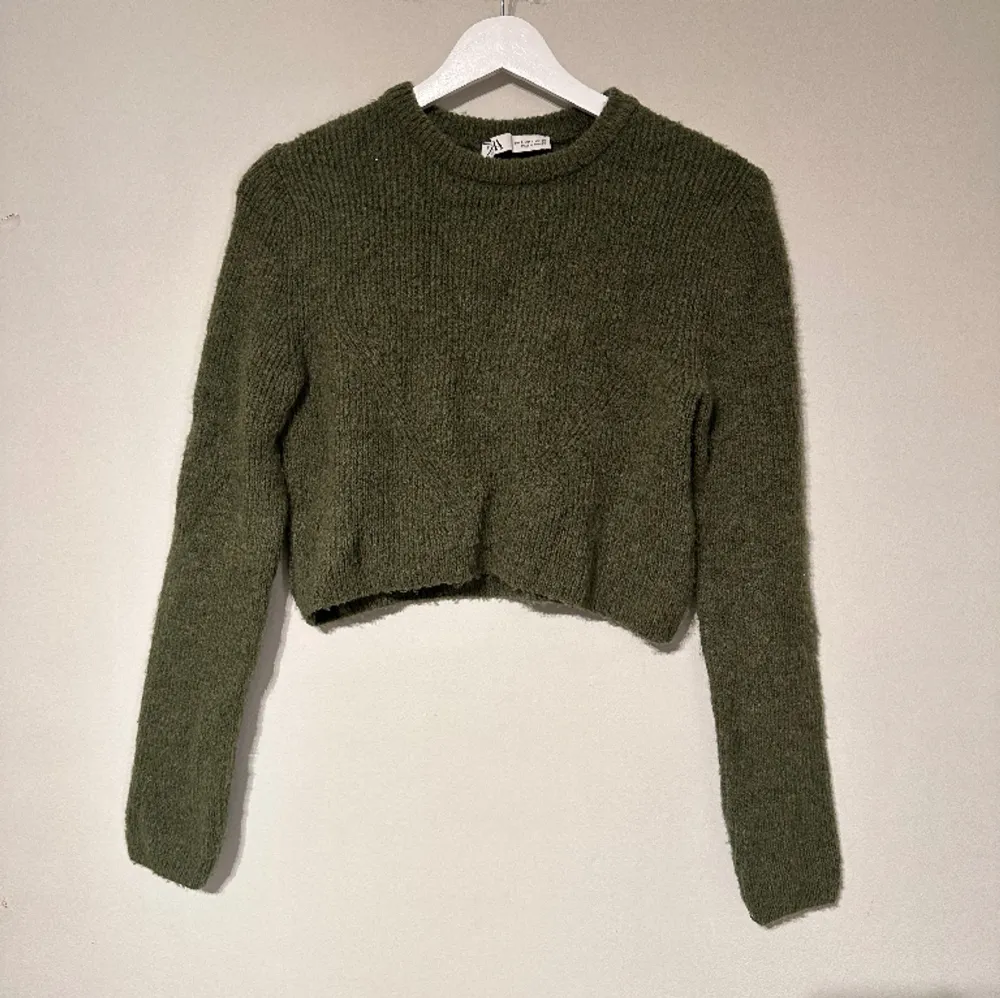 En mörkgrön stickad tröja från Zara i storlek S. Tröjan är croppad och sitter ganska tajt. Tröjan är i bra skick och har knappt använts. . Tröjor & Koftor.