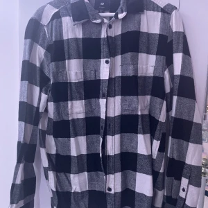 En vit och svart rutig skjorta  - Säljer min skjorta från hm använd få gånger men är i väldigt bra skick. Hör av er kring funderingar 