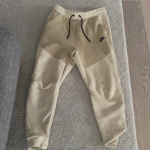 Nike tech byxor beige - Säljer nu mina Nike tech byxor för jag har tröttnat på stilen, dem är i väldigt fint skick och är knappt använda. Dem är i beige och är ganska svåra att få tag på i denhär färgen.