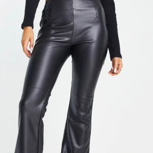 Svart byxor  - svarta utsvängda byxor med stretch i läderimitation, som är använt 1-2 gånger 