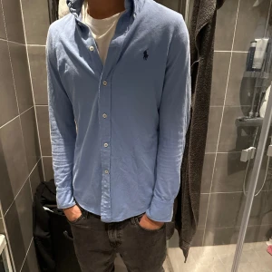 Polo Skjorta  - Tja, säljer nu denna as feta polo skjorta i färgen ljusblå🙌 Tröjan är i storlek S.  Skriv Pm vid eventuella frågor!