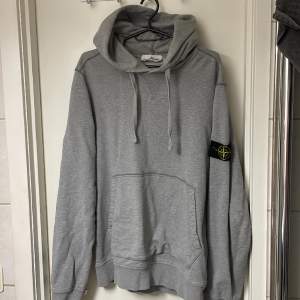 En äkta stone island hoodie som jag köpte för två år sedan. Den har ett litet hål på ena armen (se på bild) och tre mindre slitningar på andra men inget som synd märkvärdigt.  Annars väldigt snygg. Strl L  Nypris 3500kr  Mitt pris 1200kr 