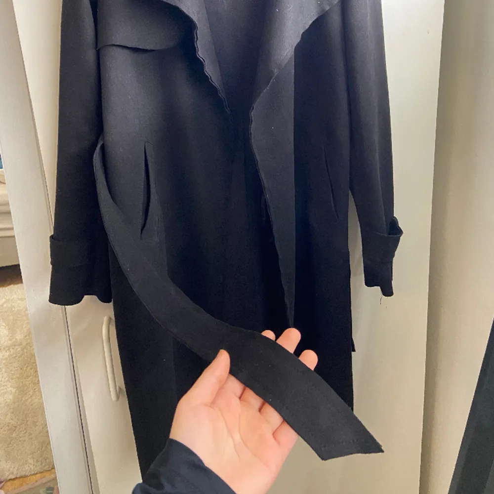 Säljer en svart trenchcoat från Missäy i storlek xxs. Med knytband runt midjan och två fickor. Säljer pågrund av att den är för liten. Längd: till knäna (är 160cm) . Jackor.