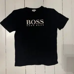 Hugo boss T-shirt i svart, säljs på grund av att den är för liten. Tröjan är i ungdomsstorlek för 14 åringar!