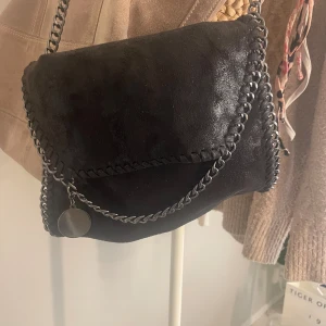 Axelremsväska med silverdetaljer - Stella mcCartney liknande väska med långt kedjeband och silverdetaljer🩶