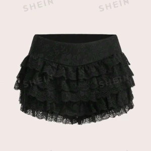 Svart spetskjol från Shein - Ett par svarta shorts från Shein med flera lager av spetsvolanger. Kjolen har en elastisk midja och är tillverkad av 90% polyester och 10% elastan.