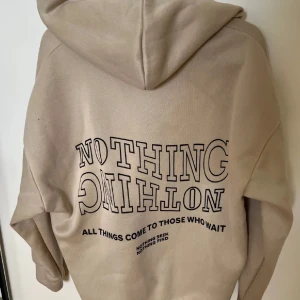 Hoodie  - Beige hoodie med snyggt tryck på ryggen 