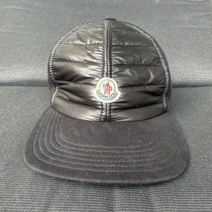 Moncler Keps - Jag säljer min one sized äkta Moncler keps på grund av ingen användning. Kepsens skick är 10/10 som nyskick, den har inte skadats någonstans. Den är köpt från Moncler i Grekland Athen. Tar även emot byten!