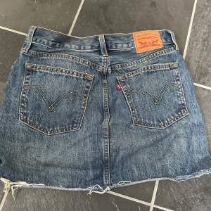 En superfin jeanskjol ifrån Levis i en mörk färg! Fint skick