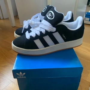 Adidas campus 00s svarta  - Säljer dessa snygga adidas campus 00s i storlek 41 1/3, nyskick. Kartong finns kvar. Svarta skosnören ingår🤗(köparen står för frakt)  