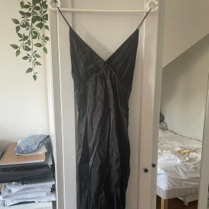 Svart klänning - En svart klänning med band och v-ringad i stolek S.