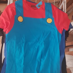Super Mario T-Shirt - T-Shirt med Super Mario Bros tryck. Marios färger. Nintendo