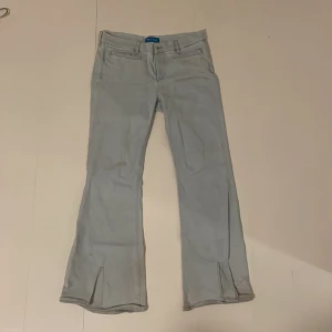 Ljusblå Lågmidjad Bootcut Jeans - Ljusblå/vita lågmidjad bootcut jeans i bra skick men de kom tyvärr inte t användning. Lite smutsiga på botten men behöver bara tvätta dem. Skriv ifall du undrar efter måtten!