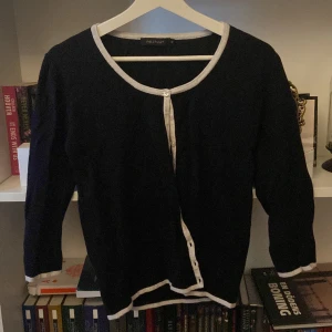 Kofta  - Det är en svart kofta men vita detaljer och trekvarts armar och en lite fick som inte syns, kommer från min måmås gaderob då den inte riktigt är min stil så säljer jag den 🫶