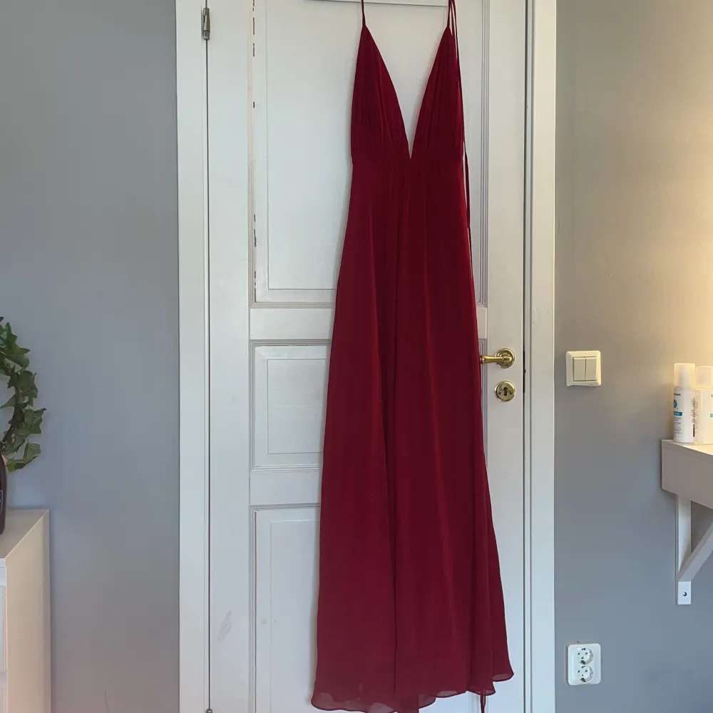 En röd balklänning med slits och öppen rygg med snören baktill som man kan välja själv hur som ska se ut i ryggen😍  Använd en gång, är av väldigt bra kvalite🙌 ORDINARIE PRIS 2100kr. Klänningar.