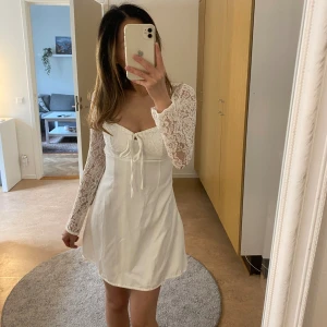 Vit spetsklänning med snörning - Superfin till sommar/midsommar/student mm. Har spetsarmar och snörning i ryggen. Aldrig använd endast testad. Var krångligt att skicka tillbaka därav försöker jag sälja vidare den till någon som kan ha större användning av den💗 Pris kan diskuteras!