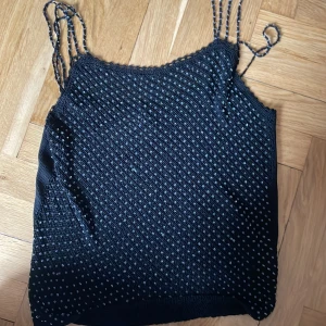 Svart topp fest  - Svart festtopp strl S köpt second hand i Göteborg på humana. Lapp kvar. Pärlor på.