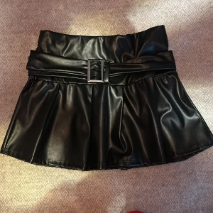 Skinnimitation minikjol med inbyggd shorts helt ny i stl XS - Miniklänning från Nellyone stl XS.Denna är väldigt kort och används till raveklubbar.