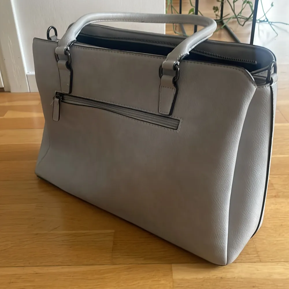 Ljusgrå handväska. Mått: ca 38 x 24  x 13 Finns en längre rem som kan sättas på (som är oanvänd). Fint skick💓. Väskor.