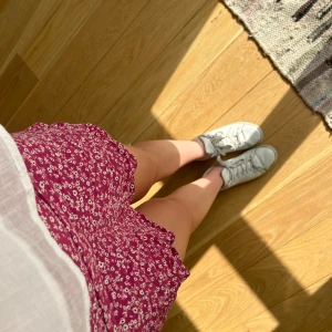 Blommig kjol - Fin rosa kjol med blommor på den har även inneshorts som sitter fast i kjolen.