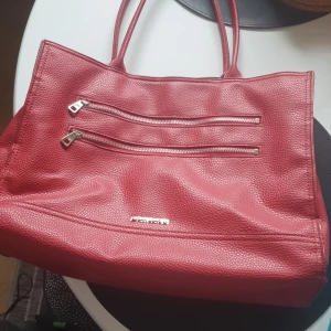 Röd Björn Borg väska  - Röd Björn Borg väska med något slitna handtag, men med en axelrem som är ny. 