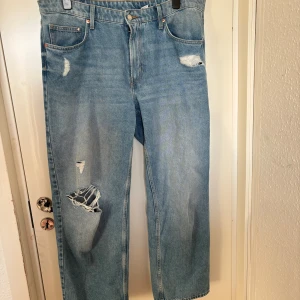 Baggy jeans - Baggy jeans med hål i, klassas som low wait men kan definitivt ha på som högmidjade. Extra öglor till skärp er fastsydda på baksidan. Storlek 48 men mer likt 50/52
