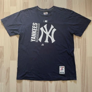 Majestic New York Yankees T-Shirt - 199kr - En mörkblå autentisk Majestic New York Yankees t-shirt i storlek extra Large. 100% bomull. Stort tryckt print på framsidan vid bröstet, ett mindre tryckt print i tröjans hörn. För mått/fler bilder skriv privat.