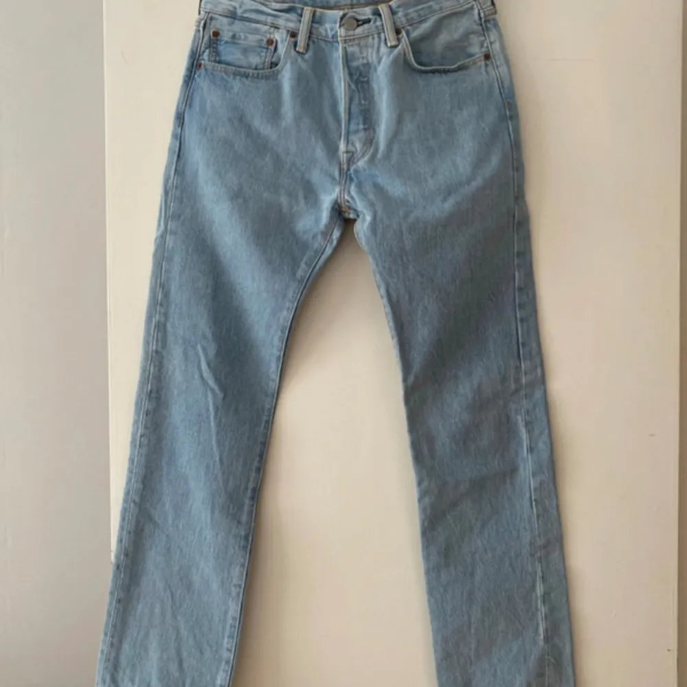 Ett par Levi's 501 jeans i ljusblå färg. De har en rak passform och är i gott skick.. Jeans & Byxor.